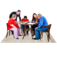 A group of people gathered round a table, looking at some papers together.