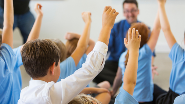 Image showing children raising their hand in a classroom setting